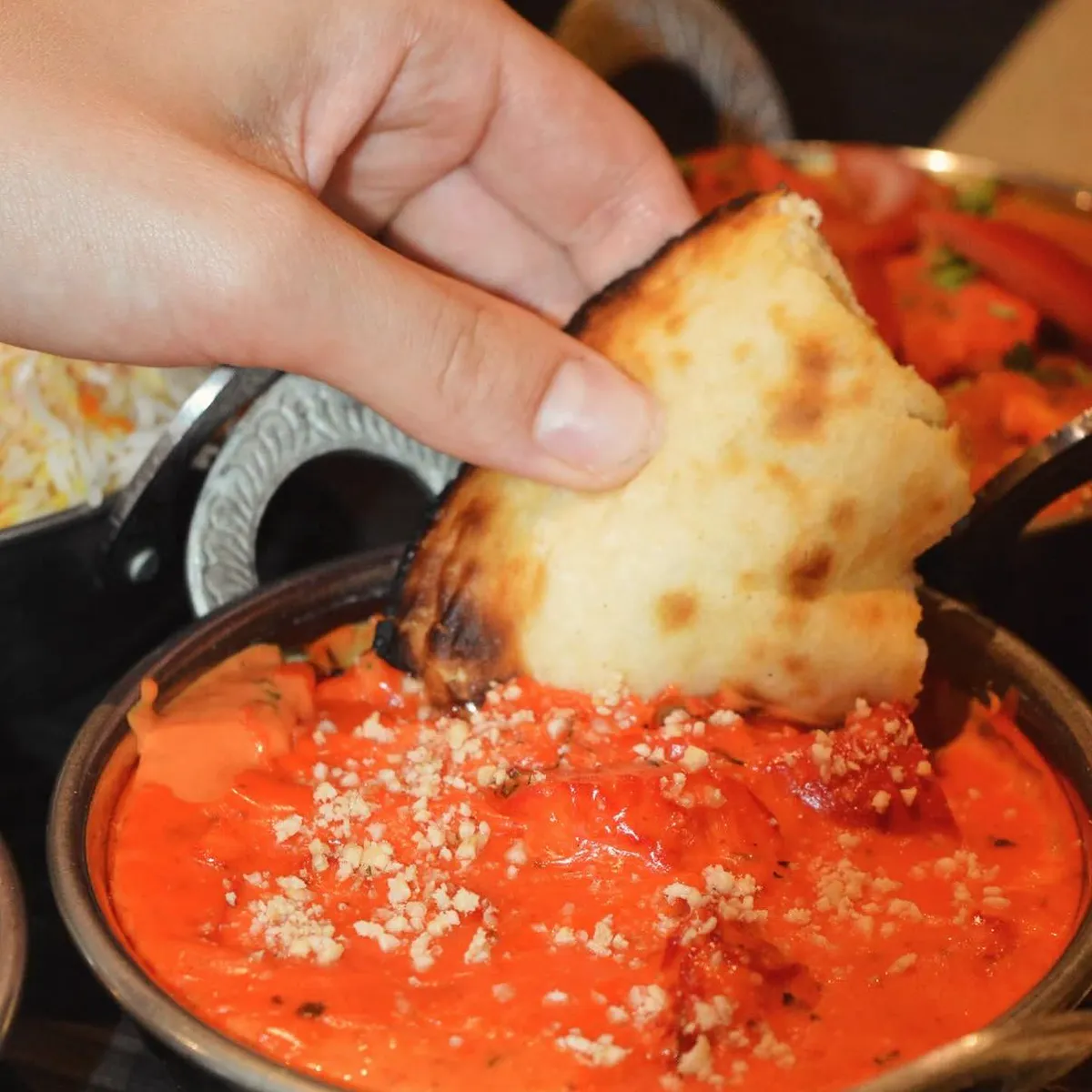 Dipping naan into the butter chicken
