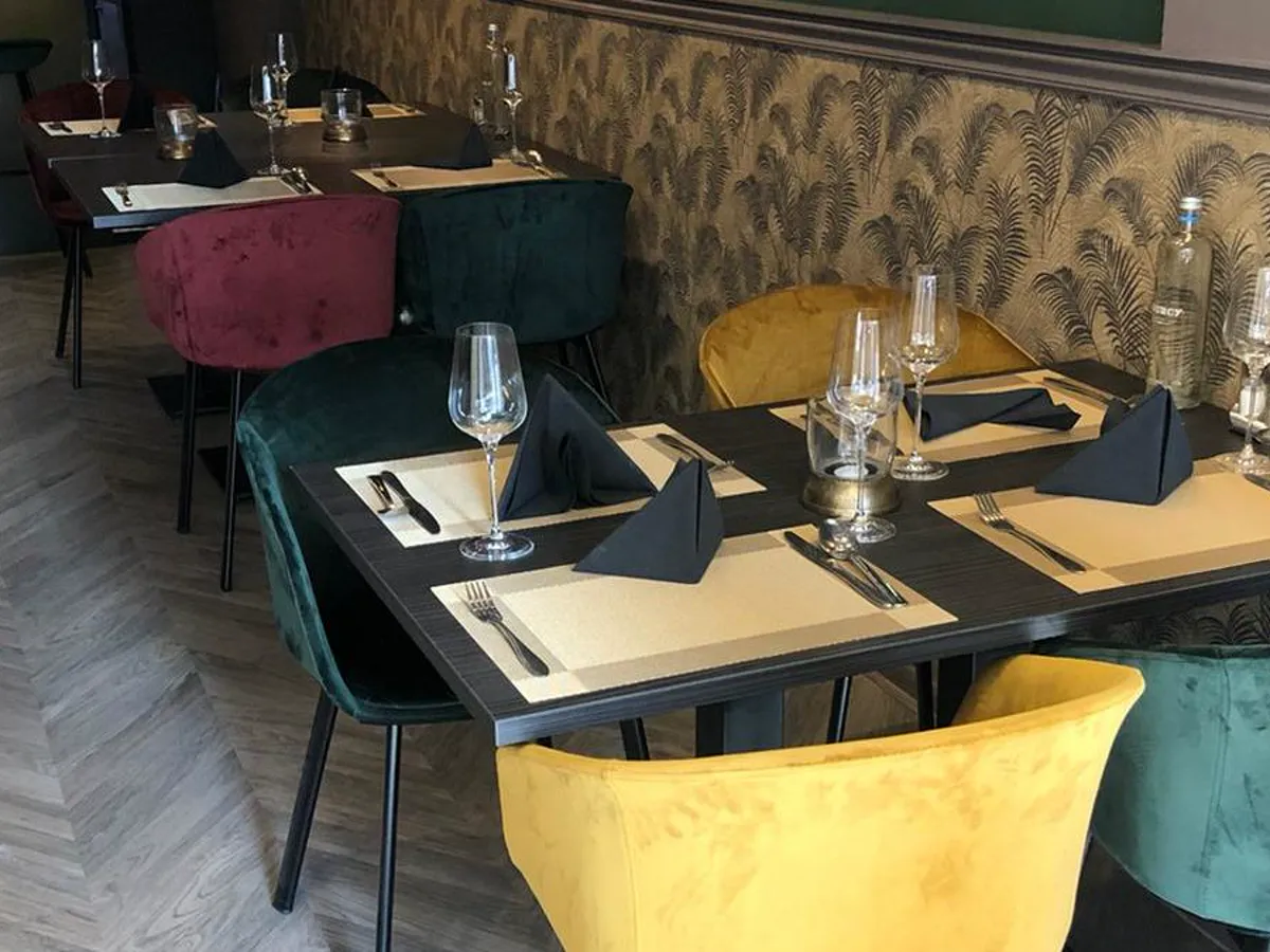 Set tables with green and yellow velvet chairs