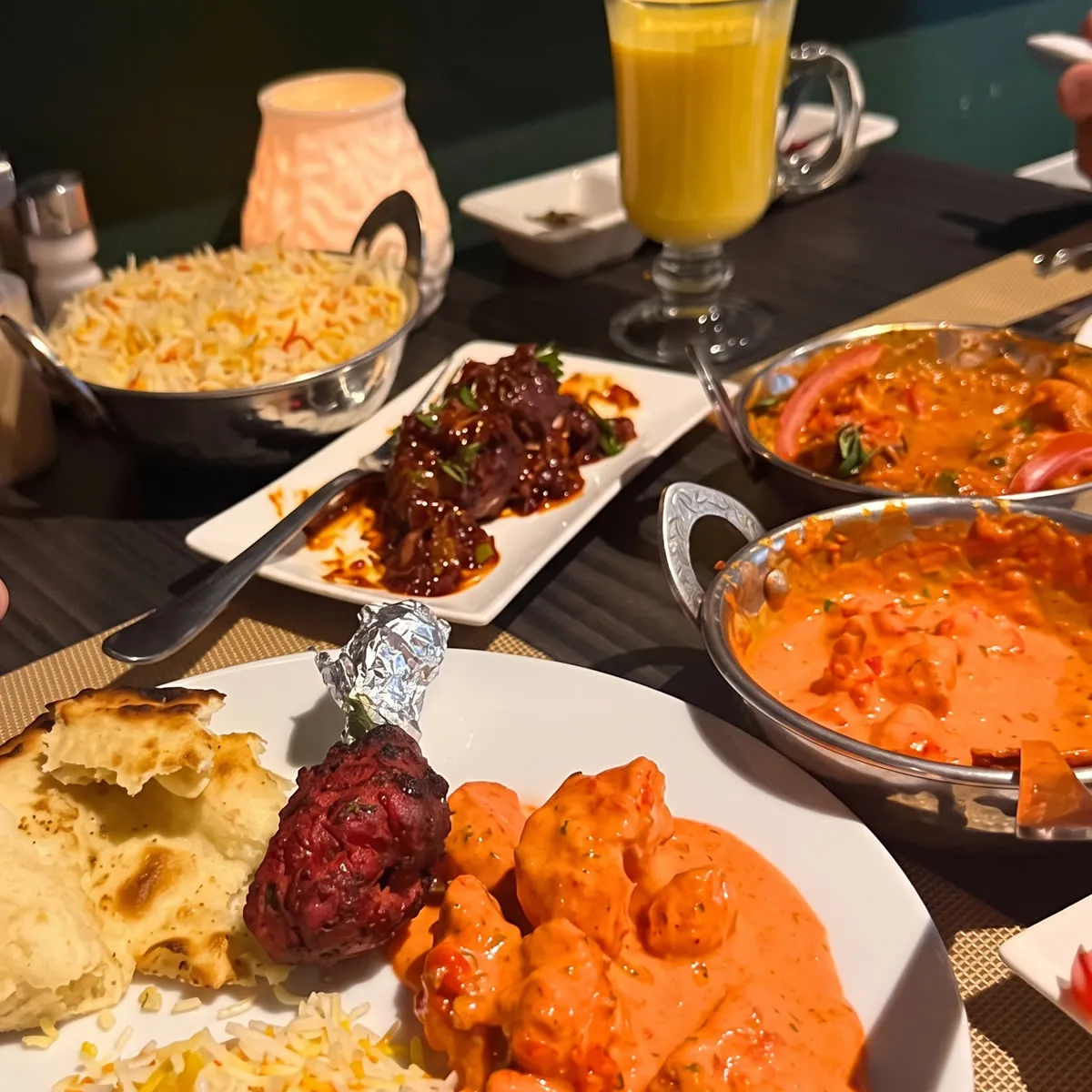 A table at Spices with butter chicken, naan, rice and tandoori
